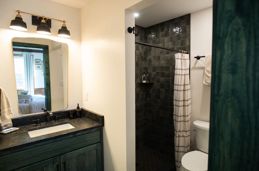 Private bath with sink, tiled shower, and toilet.